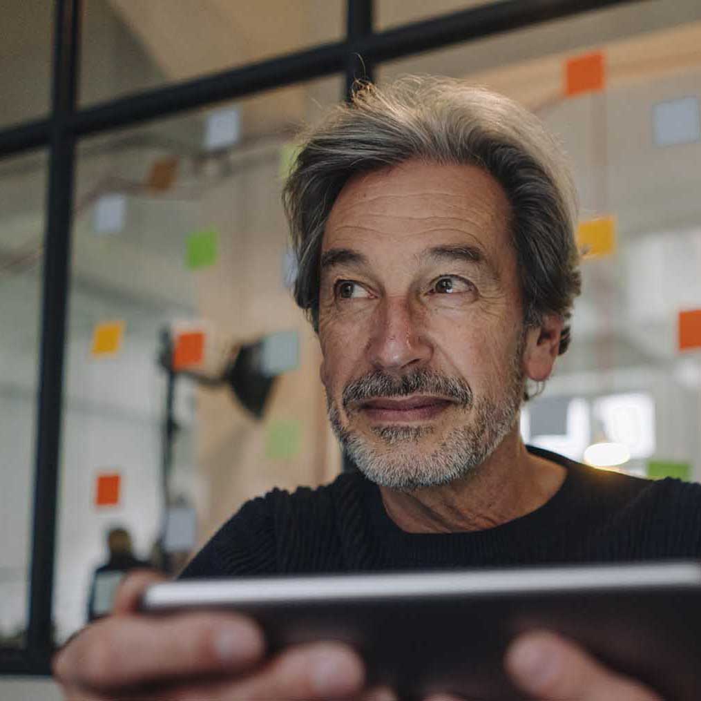 Senior businessman with tablet in office